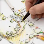 Hand drawing a colorful garden landscape plan with pencils.
