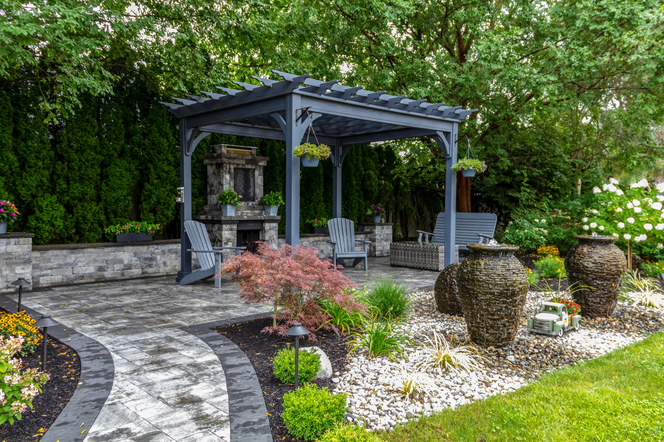Elegant backyard pergola with seating and decorative plants.