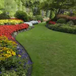 Colorful flower beds border a lush green garden pathway.
