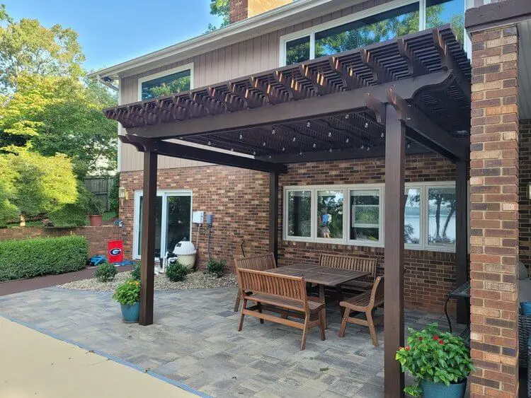 Backyard patio with pergola and seating area.